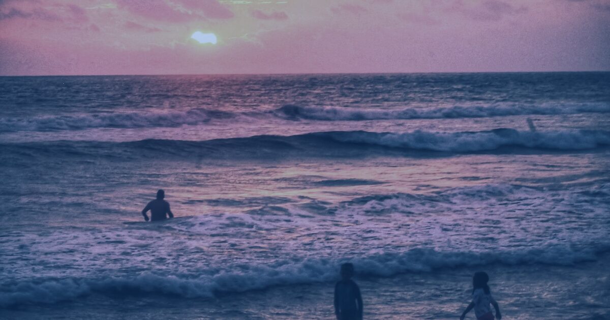 Praia ao pôr do sol em região litorânea de empreendimentos de alto padrão